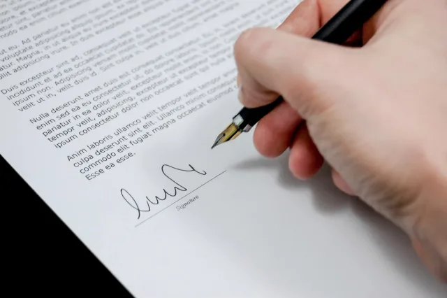 Free hand holding pen signing. What should a creator contracts planning template include?
